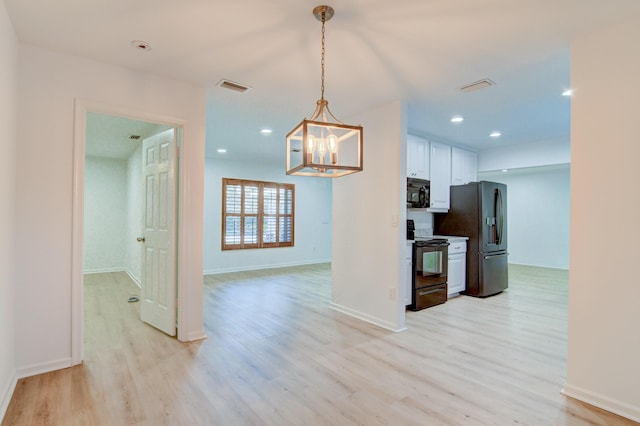 kitchen with decorative light fixtures, visible vents, light wood-style floors, white cabinets, and black appliances