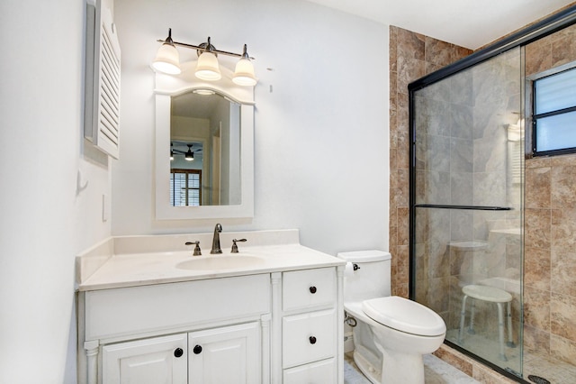 bathroom with ceiling fan, a stall shower, vanity, and toilet