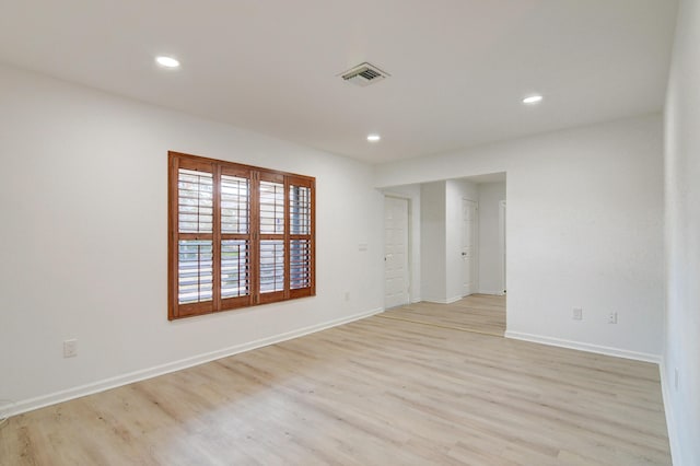 empty room featuring recessed lighting, light wood-type flooring, visible vents, and baseboards