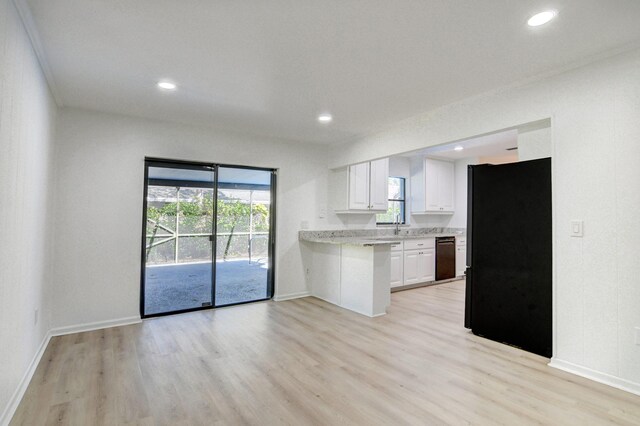 kitchen featuring recessed lighting, light countertops, light wood-style floors, white cabinets, and black appliances