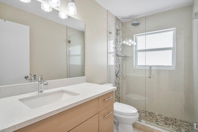 bathroom featuring a stall shower, vanity, and toilet