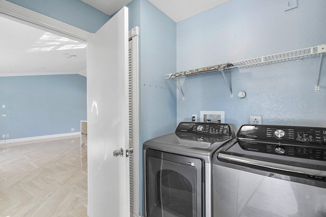 clothes washing area with laundry area, baseboards, and independent washer and dryer