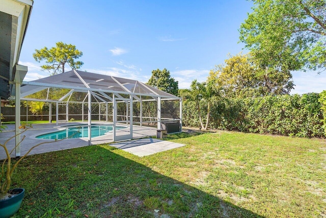 pool featuring a lanai, a patio area, and a lawn