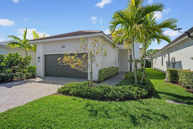 view of front of property with an attached garage, a front lawn, decorative driveway, and stucco siding