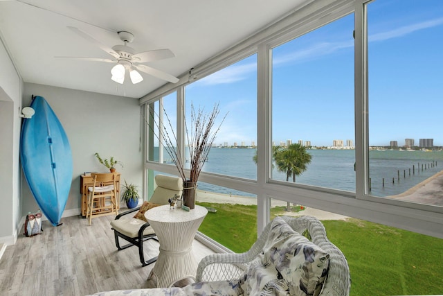 sunroom / solarium featuring a water view and ceiling fan