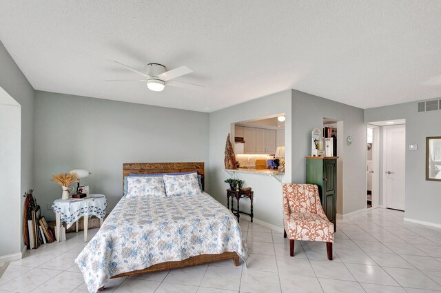 bedroom featuring light tile patterned floors, a textured ceiling, visible vents, baseboards, and a ceiling fan