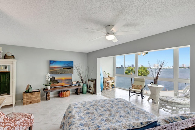 bedroom with ceiling fan, a textured ceiling, and light tile patterned flooring