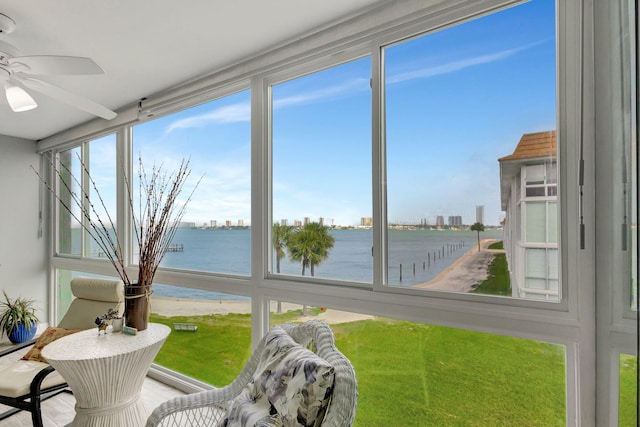 sunroom with a water view and ceiling fan