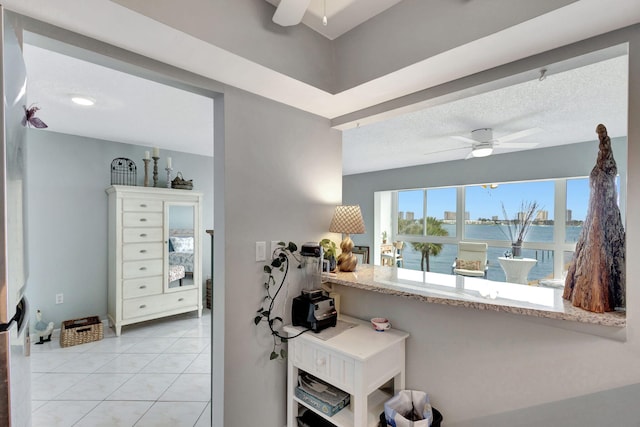 interior space with a textured ceiling, a ceiling fan, and tile patterned floors