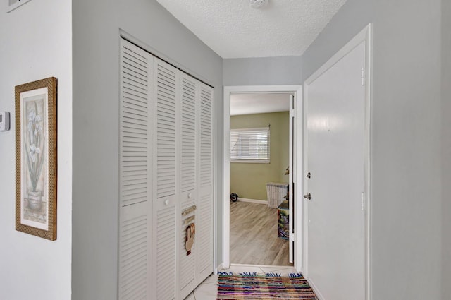 corridor with baseboards and a textured ceiling