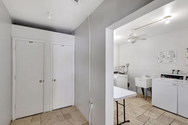 community laundry room featuring ceiling fan, a sink, and washing machine and clothes dryer