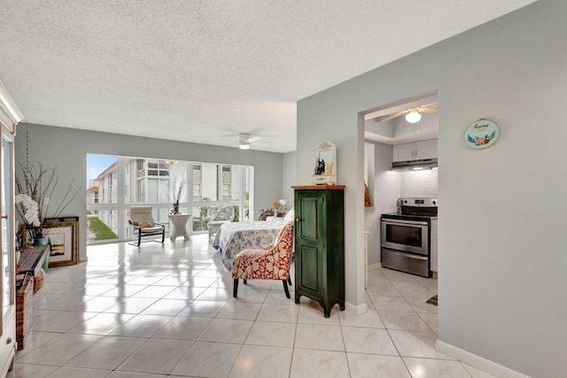 living area with baseboards, a textured ceiling, and light tile patterned flooring