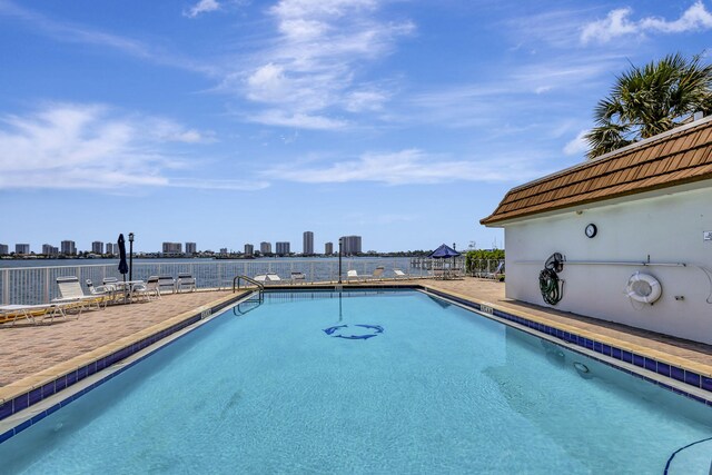 community pool with a patio area and a city view