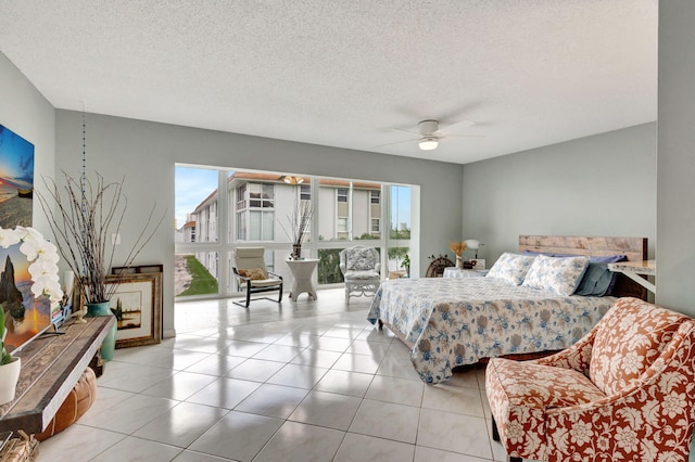 tiled bedroom featuring multiple windows, a ceiling fan, and a textured ceiling