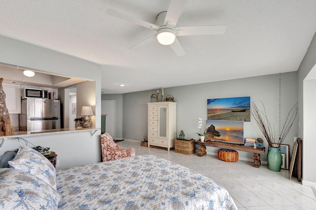 bedroom featuring light tile patterned floors, ceiling fan, a textured ceiling, baseboards, and freestanding refrigerator