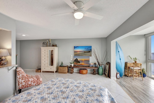 tiled bedroom featuring a textured ceiling, a ceiling fan, and baseboards