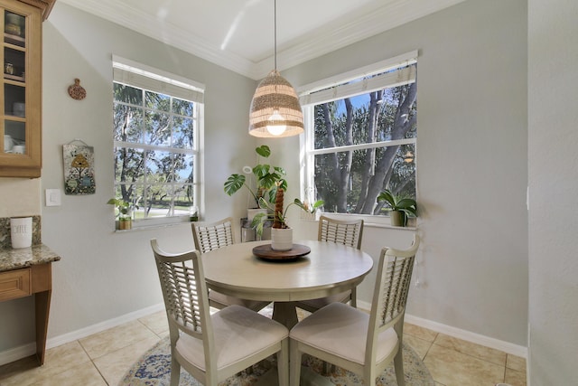 dining room featuring light tile patterned floors, baseboards, and crown molding