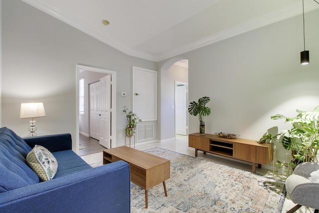 living room with baseboards, visible vents, arched walkways, and crown molding