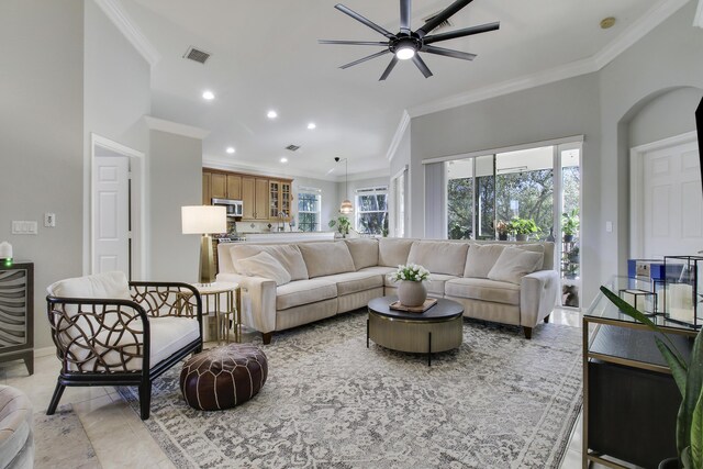 living area with recessed lighting, a ceiling fan, baseboards, visible vents, and ornamental molding