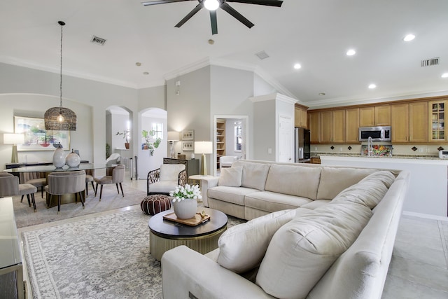 living area with visible vents, arched walkways, crown molding, and recessed lighting