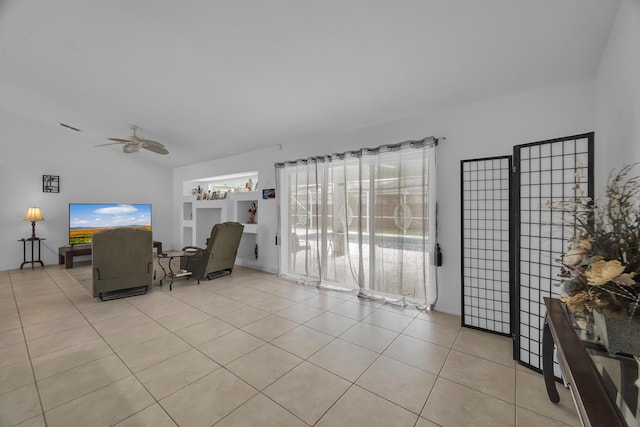 living area featuring light tile patterned floors, ceiling fan, and vaulted ceiling