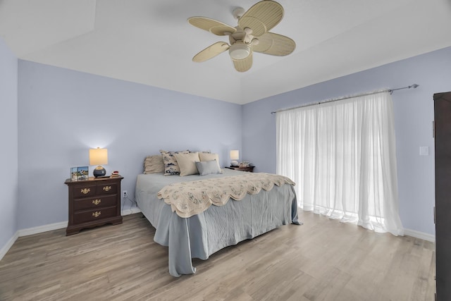 bedroom with ceiling fan, baseboards, and wood finished floors