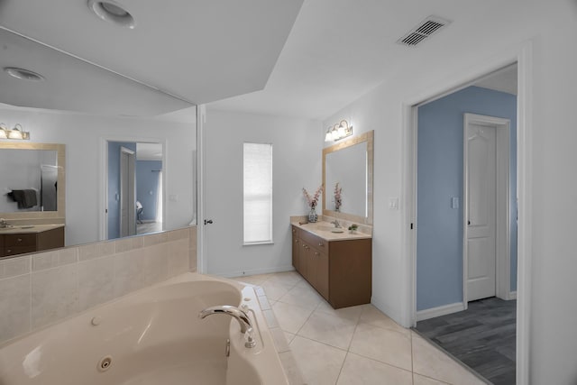 bathroom featuring baseboards, visible vents, tile patterned floors, a jetted tub, and vanity