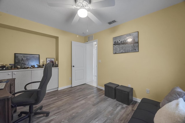 office area with visible vents, baseboards, and wood finished floors