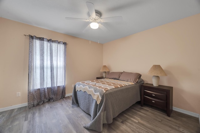 bedroom with ceiling fan, baseboards, and wood finished floors