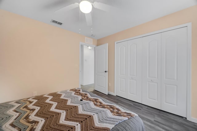 unfurnished bedroom featuring a closet, wood finished floors, visible vents, and a ceiling fan