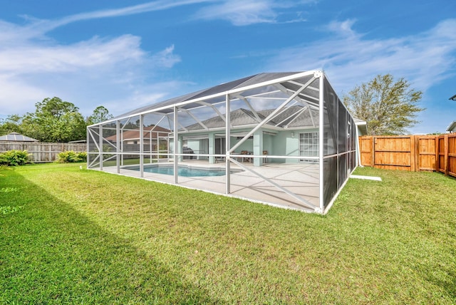 back of property with a lanai, a fenced backyard, a fenced in pool, and a lawn