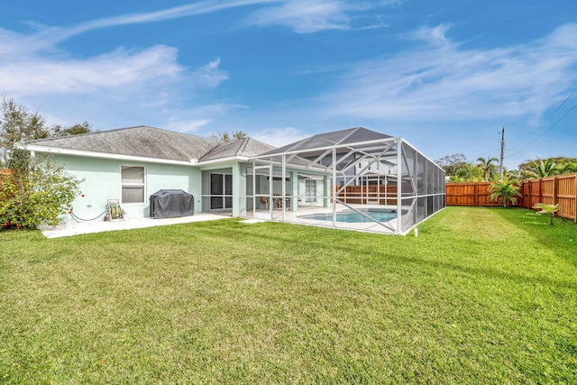 back of property featuring a yard, a fenced backyard, glass enclosure, and a fenced in pool