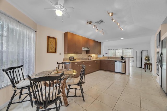 kitchen featuring a peninsula, light tile patterned floors, visible vents, and dishwasher