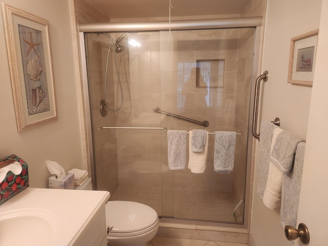 full bathroom with a stall shower, vanity, toilet, and tile patterned floors