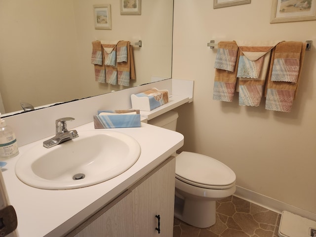 half bath with tile patterned flooring, baseboards, vanity, and toilet