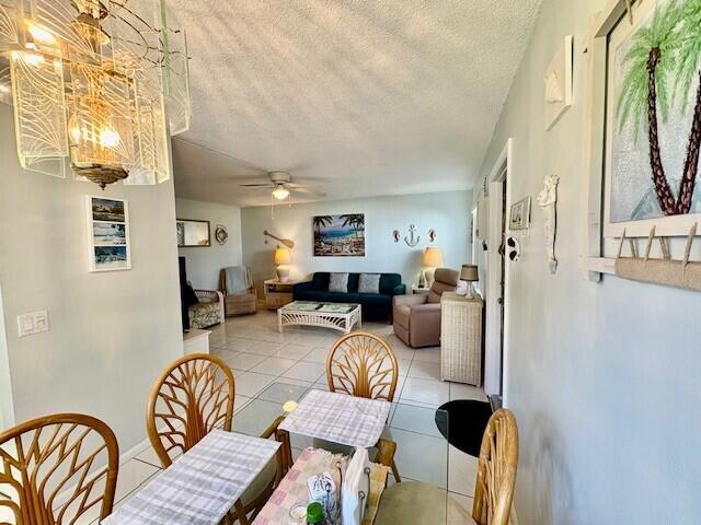 dining space with tile patterned floors, a textured ceiling, and ceiling fan