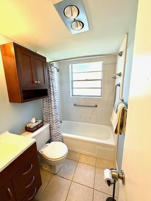 full bathroom with tile patterned flooring, toilet, vanity, and shower / bath combo