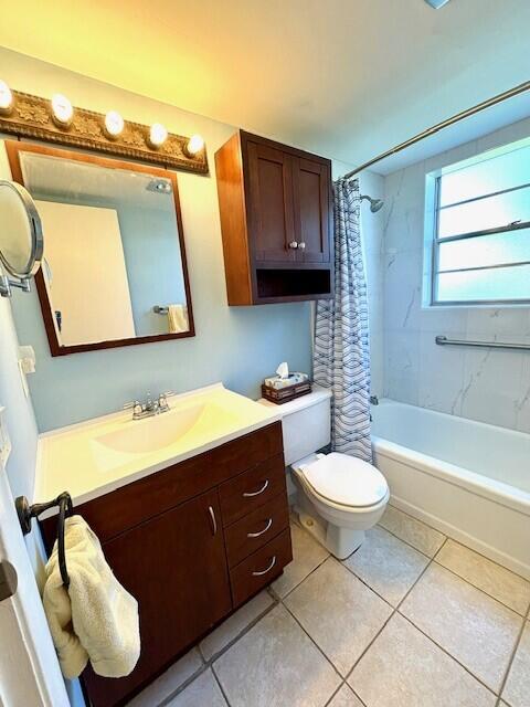 bathroom featuring vanity, shower / bath combination with curtain, toilet, and tile patterned floors