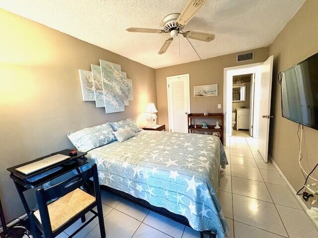 tiled bedroom featuring visible vents, ceiling fan, a textured ceiling, and baseboards