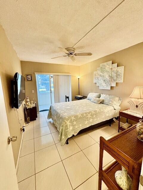 bedroom with light tile patterned floors, a ceiling fan, baseboards, access to exterior, and a textured ceiling