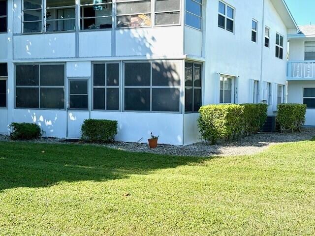 exterior space featuring stucco siding and a yard