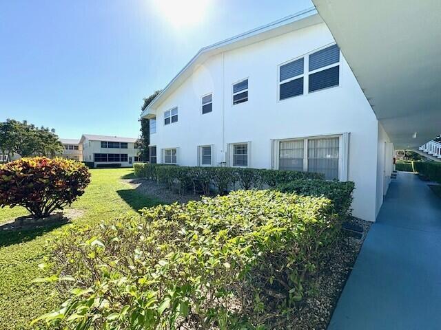 view of side of home with a lawn and stucco siding