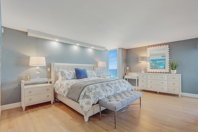 bedroom with light wood-style flooring and baseboards