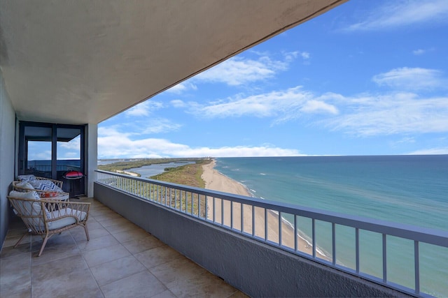 balcony featuring a water view and a beach view