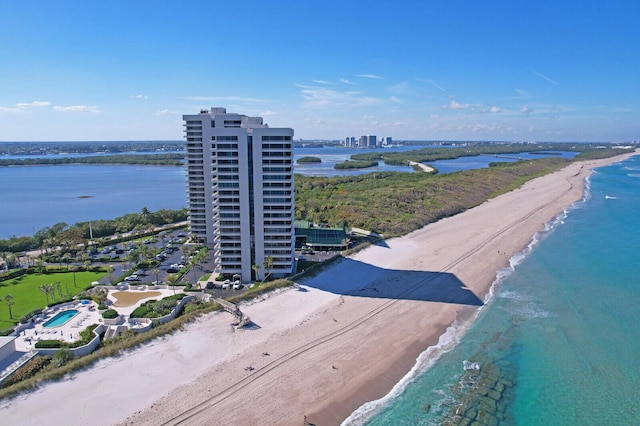 drone / aerial view featuring a water view, a beach view, and a city view