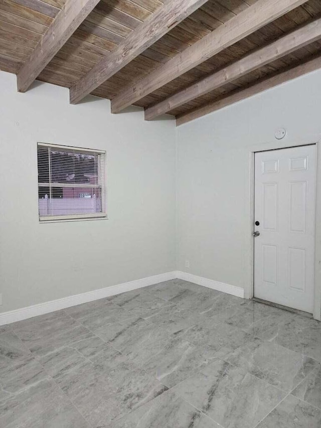 empty room with wooden ceiling, beamed ceiling, and baseboards