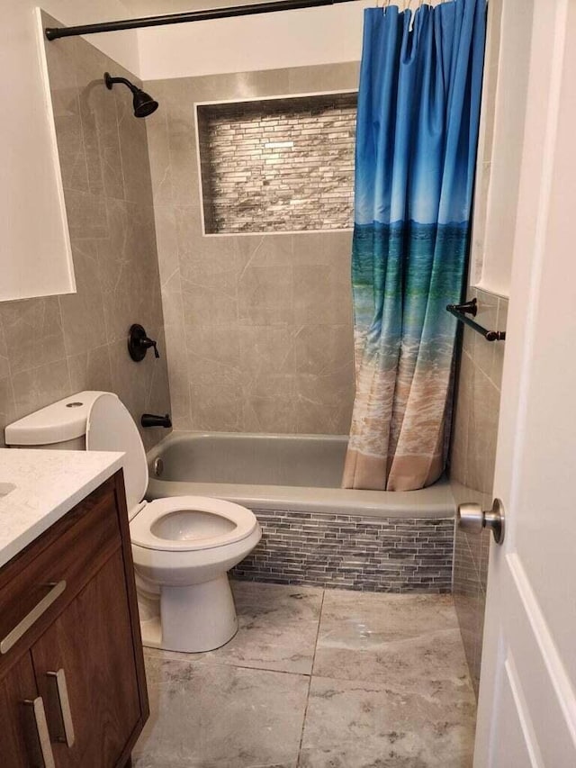 bathroom with tiled shower / bath combo, vanity, toilet, and tile walls