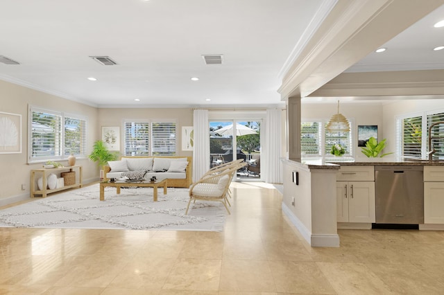 living area with crown molding, plenty of natural light, and visible vents