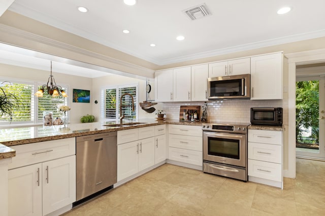 kitchen with visible vents, light stone counters, decorative backsplash, stainless steel appliances, and a sink