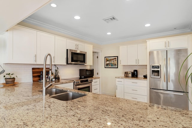 kitchen featuring visible vents, crown molding, light stone countertops, stainless steel appliances, and a sink